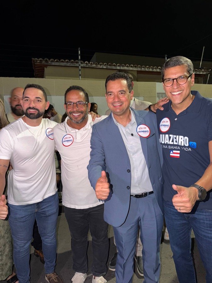 Jayminho com apoiadores usando broches da campanha em um encontro à noite